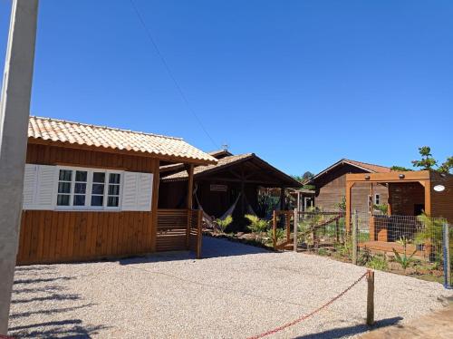 uma casa com uma cerca em frente em Cabanas MORIÁ em Garopaba