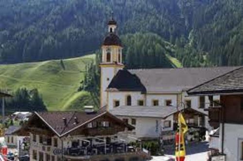 a large white building with a clock tower on top at Hotel Hoferwirt in Neustift im Stubaital