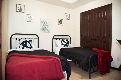 duas camas num quarto com lençóis vermelhos e pretos em 1 Min to University UTRGV 2BD 2BT town suite em Edinburg