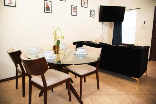 a dining room with a table and chairs and a couch at 1 Min to University UTRGV 2BD 2BT town suite in Edinburg