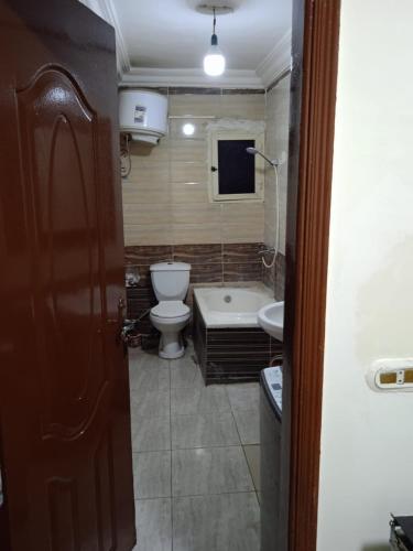 La salle de bains est pourvue de toilettes, d'une baignoire et d'un lavabo. dans l'établissement HeliopolisStar, au Caire