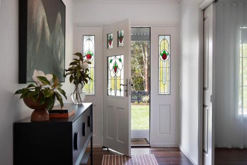 a hallway with a door with stained glass windows at Peahen House in Trentham