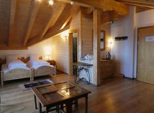 a room with two beds and a table in it at Hotel Harmony Tigilou Belalp in Belalp