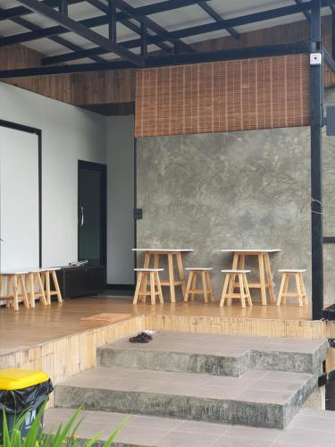 a room with two tables and stools in front of a wall at เฌอปือ เชียงใหม่ Cherpue Chiangmai in Ban Mae Na