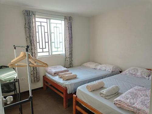 2 camas individuales en una habitación con ventana en CASA CON COCHERA CERCA A LA PLAYA PlMENTEL, en Chiclayo