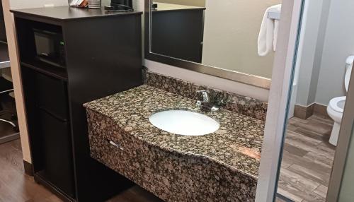 a bathroom with a sink with a granite counter top at Red Roof Inn & Suites Richland in Richland
