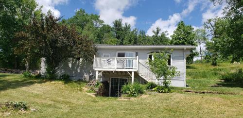 a house with a balcony and a yard at Quaint Cabin with Private Dock in Fergus Falls