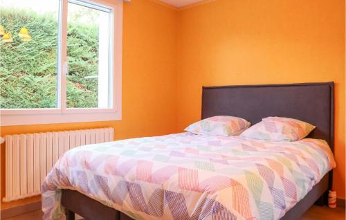 a bedroom with a bed with orange walls and a window at 3 Bedroom Awesome Home In Puy-saint-martin in Puy-Saint-Martin