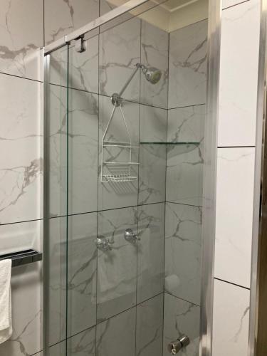 baño con ducha y puerta de cristal en Windsurfer Resort en Gold Coast