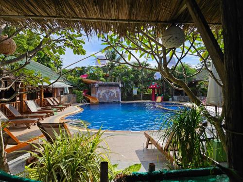 a large swimming pool with lounge chairs and a resort at Lanta Riviera Beach Resort in Ko Lanta