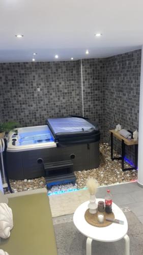 uma banheira de hidromassagem num quarto com uma mesa em Dream SPA em Vitrolles