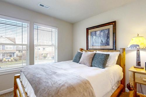 a bedroom with a bed with a lamp and a window at Around the Bend in Bend