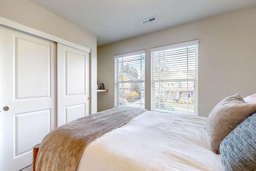 a bedroom with a bed and a large window at Around the Bend in Bend