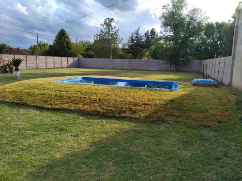 a backyard with a pool in the grass at Family Place II in Luján