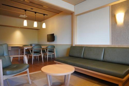 a waiting room with a couch and chairs and a table at Dantokan Kikunoya in Otsu