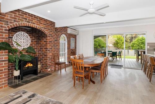 a living room with a brick fireplace and a table and chairs at Sandy Feet Retreat in Geographe