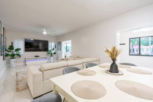 a white living room with a table and chairs at New Miami & Calle Ocho Home with Arcade! in Miami