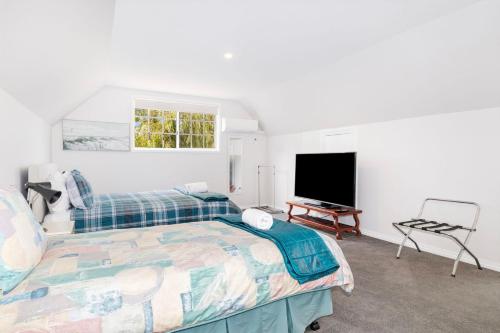 sypialnia z łóżkiem i telewizorem z płaskim ekranem w obiekcie Sandy Feet Retreat w mieście Geographe