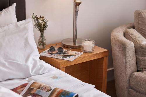 Rydges Resort Hunter Valley في لوفديل: سرير وطاولة بجانب كرسي وجلسة ليلية مع سرير