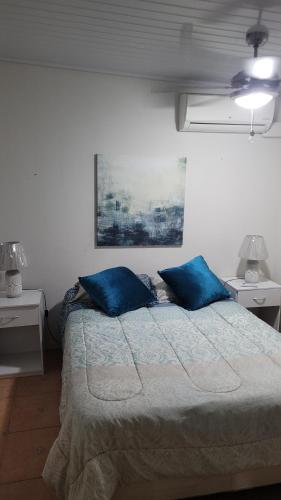 a bedroom with a bed with two blue pillows at Acogedor apartamento in San Miguelito