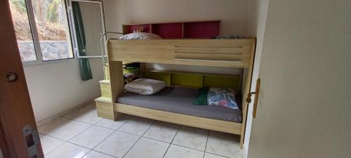 a small wooden bunk bed in a room at Meublé tourisme La Montagneuse in Salazie