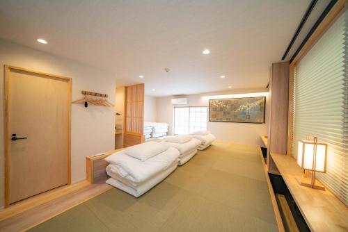 a living room with a row of white couches at SHITAMACHI PLACE TOKYO in Tokyo