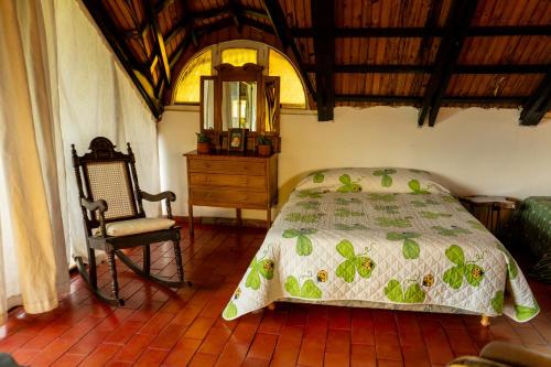 a bedroom with a bed and a chair and a dresser at " Casa quinta "San Bernardo" Con Pileta y amplio jardín in Posadas