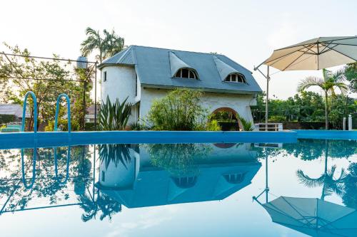 una casa se refleja en el agua de una piscina en " Casa quinta "San Bernardo" Con Pileta y amplio jardín en Posadas