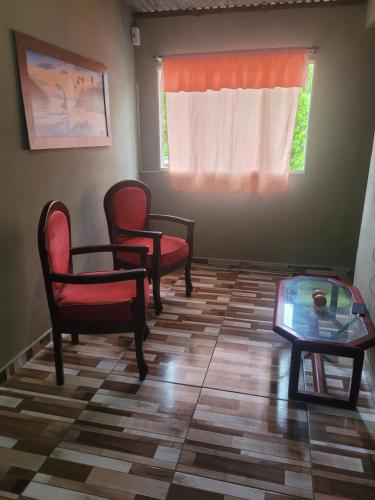 uma sala de espera com cadeiras, uma mesa e uma janela em Casa de praia em carne de vaca em Goiana
