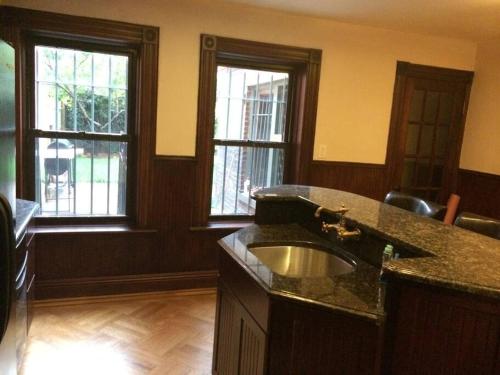 a kitchen with a sink and two windows at Garden Apartment with Private Entry in Brooklyn