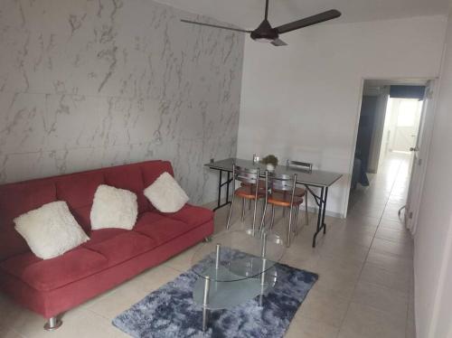 a living room with a red couch and a table at Hospedaje con Jacqueline in Boca del Río