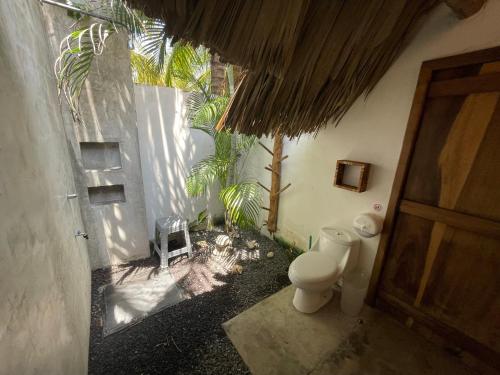 uma casa de banho com WC ao lado de um edifício em MAR Y PALMA PLAYA PAREDON em El Paredón Buena Vista