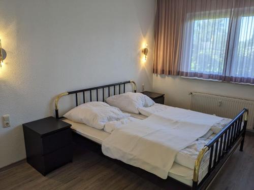 キュールングスボルンにあるFerienanlage-Reriker-Strasse-EG-rechts-119のベッドルーム1室(白いシーツと枕のベッド1台付)