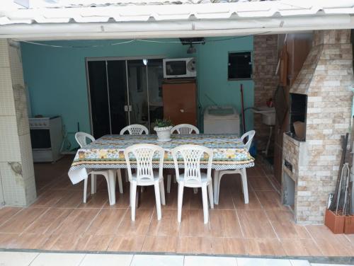 a dining table and chairs on a patio at Casas de Aluguel da Lulu in Itapema