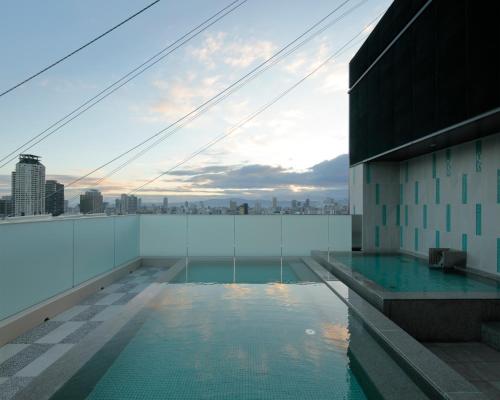 ein Pool auf dem Dach eines Gebäudes in der Unterkunft Candeo Hotels Osaka Shinsaibashi in Osaka