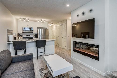 a living room with a couch and a fireplace at Cozy New Suite in Seton, South Calgary in Calgary