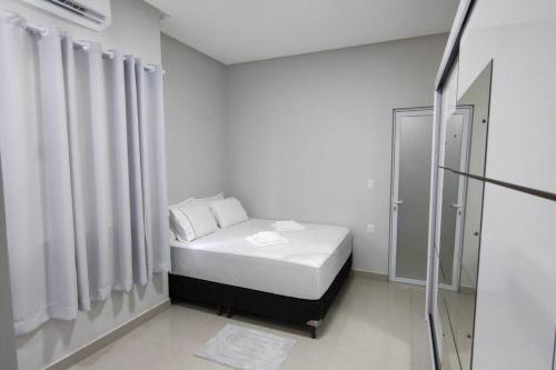 Dormitorio pequeño con cama y ducha en Casa TOP 1 Suite e 2 Quartos todos com Ar Condicionado, en Guanambi