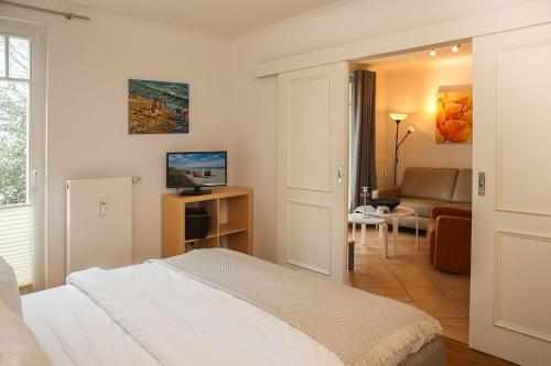 キュールングスボルンにあるDuenenschloss-Haus-2-Wohnung-6-444のベッドルーム1室(ベッド1台付)、リビングルームが備わります。