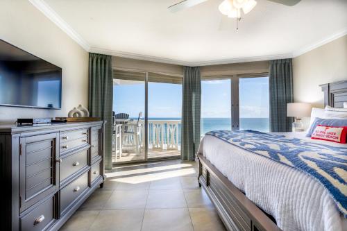 a bedroom with a bed and a view of the ocean at Paloma Penthouse in Ormond Beach