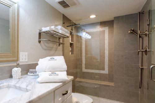 a bathroom with a shower and a toilet and a sink at Paloma Penthouse in Ormond Beach