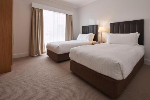 a hotel room with two beds and a window at Rydges Resort Hunter Valley in Lovedale