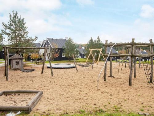 an empty playground with swings in the sand at Modern holiday home with sauna in Gjern
