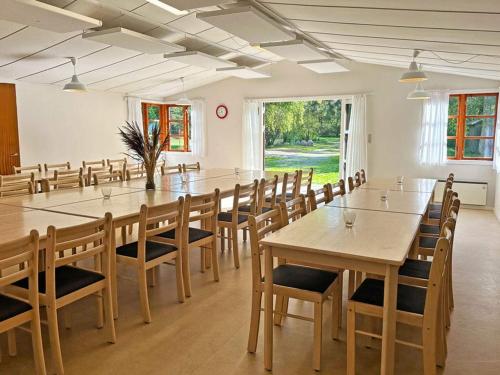 Cette grande chambre comprend une grande table et des chaises. dans l'établissement Holiday home Aakirkeby VI, à Vester Sømarken