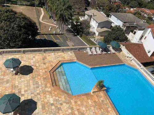 an overhead view of a swimming pool with chairs and umbrellas at Piemonte Flat Hotel in Serra Negra