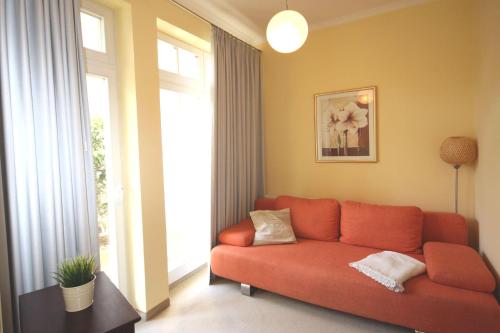 キュールングスボルンにあるDuenenschloss-Haus-1-Wohnung-6-389のリビングルーム(赤いソファ、窓付)