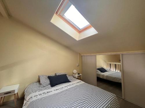 a bedroom with a large bed and a skylight at Appartement Saint-Jean-de-Luz, 1 pièce, 4 personnes - FR-1-239-576 in Saint-Jean-de-Luz