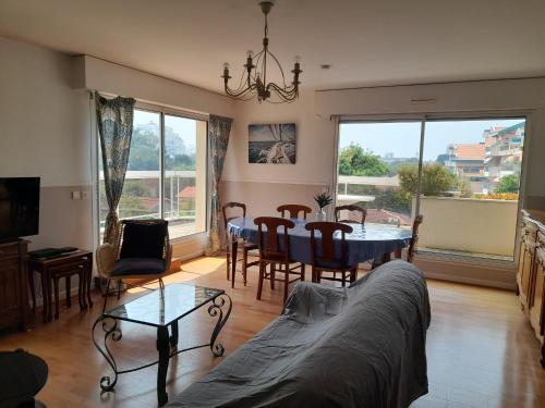 un salon avec un canapé, une table et des chaises dans l'établissement Arcachon: T3 lumineux avec parking privé, accès plage, wifi - FR-1-319-461, à Arcachon