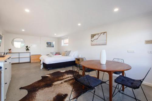een slaapkamer met een bed en een tafel en stoelen bij Studio Escape in Hamilton Hill