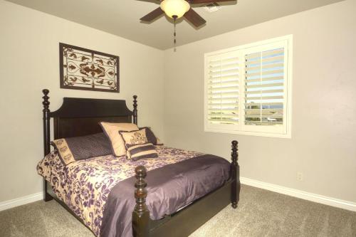 哈瓦苏湖城Sunny Ridge Elegance的一间卧室配有一张带吊扇和窗户的床。