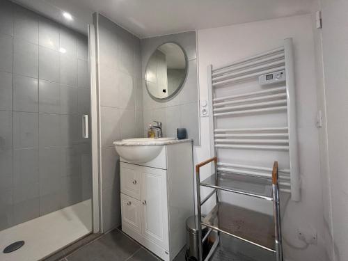 ein weißes Bad mit einem Waschbecken und einer Dusche in der Unterkunft Appartement Saint-Jean-de-Luz, 2 pièces, 4 personnes - FR-1-239-974 in Saint-Jean-de-Luz